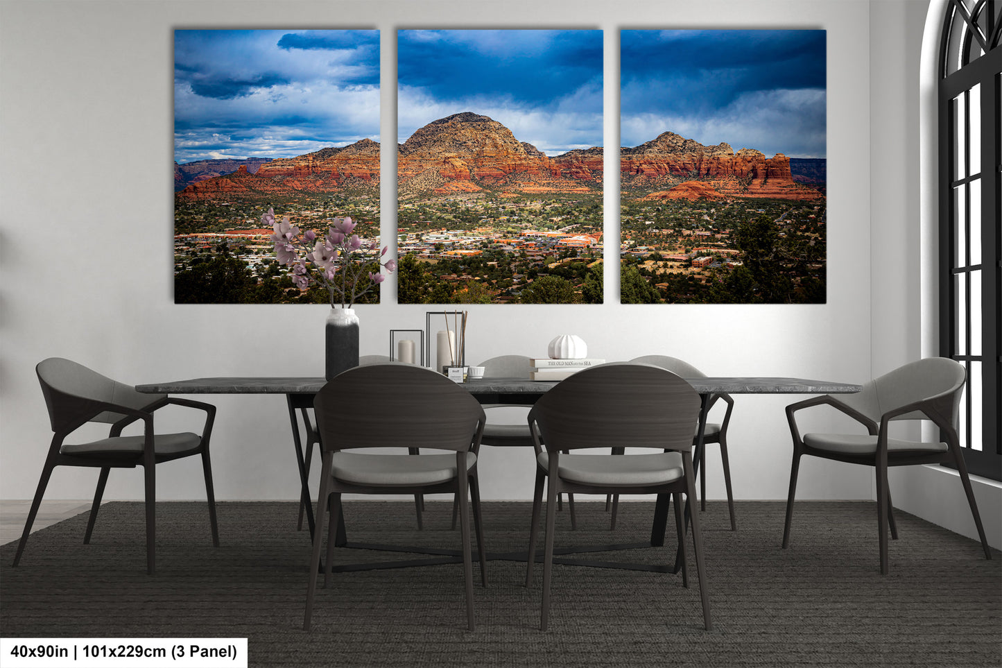 a dining room table with four chairs and three pictures on the wall