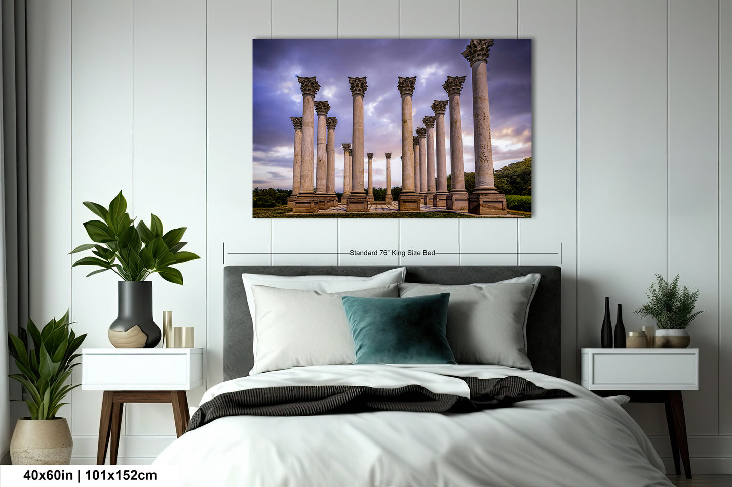 a bed with a white comforter and a painting on the wall