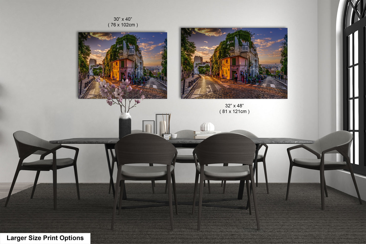 a dining room table with four chairs and two pictures on the wall