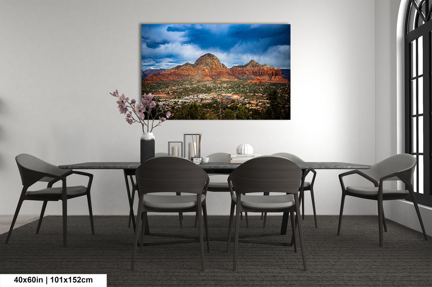 a dining room table with chairs and a painting on the wall