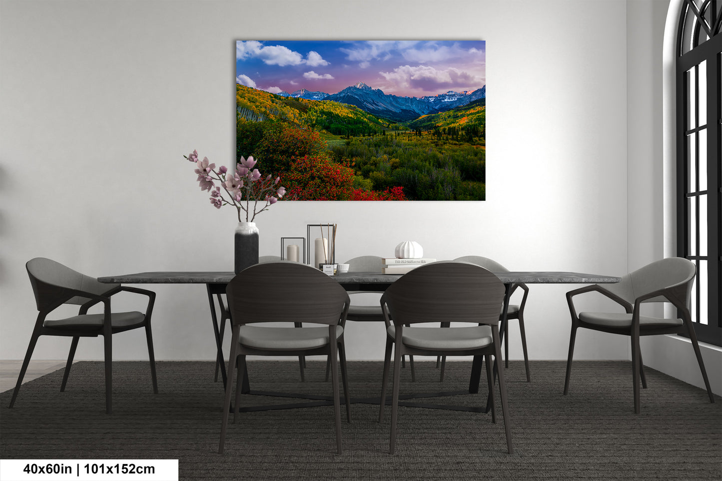 a dining room table with chairs and a painting on the wall