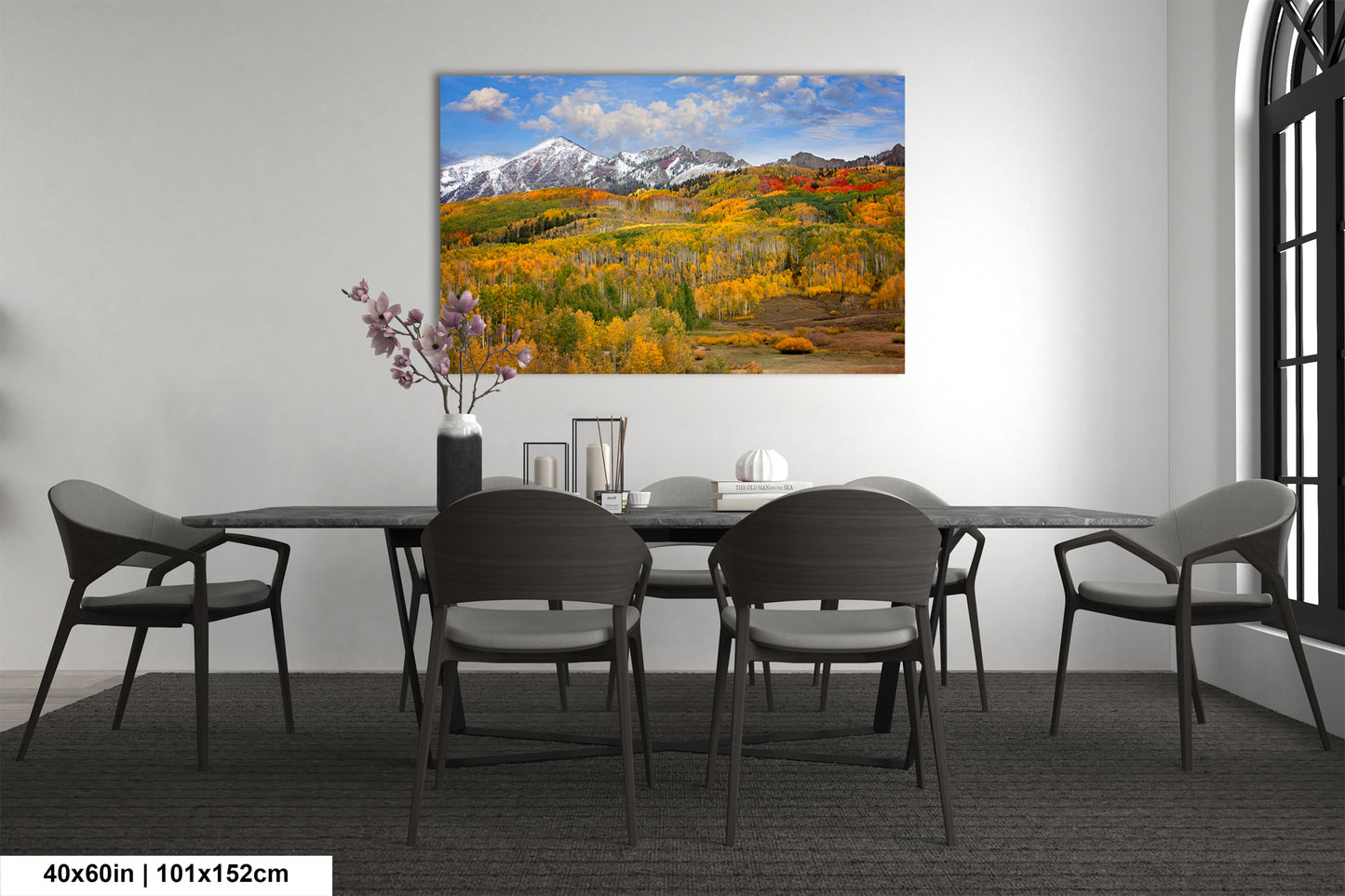 a dining room table with chairs and a painting on the wall