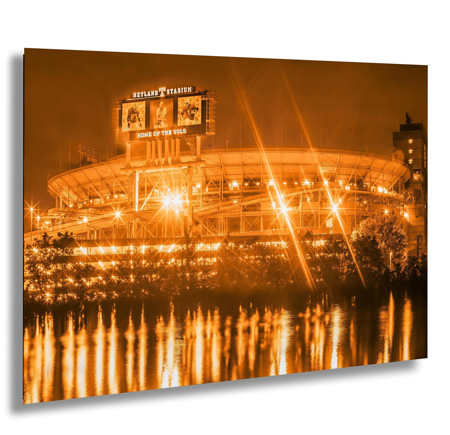 a stadium lit up at night with lights reflecting in the water