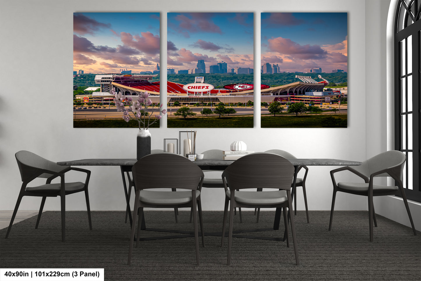 a dining room table with four chairs and a large picture of a stadium
