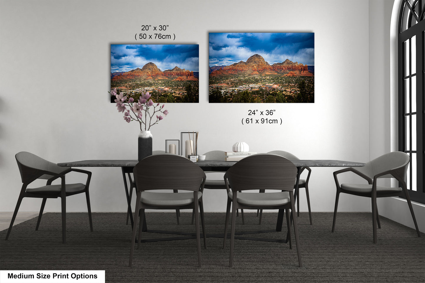 a dining table with four chairs and a vase of flowers