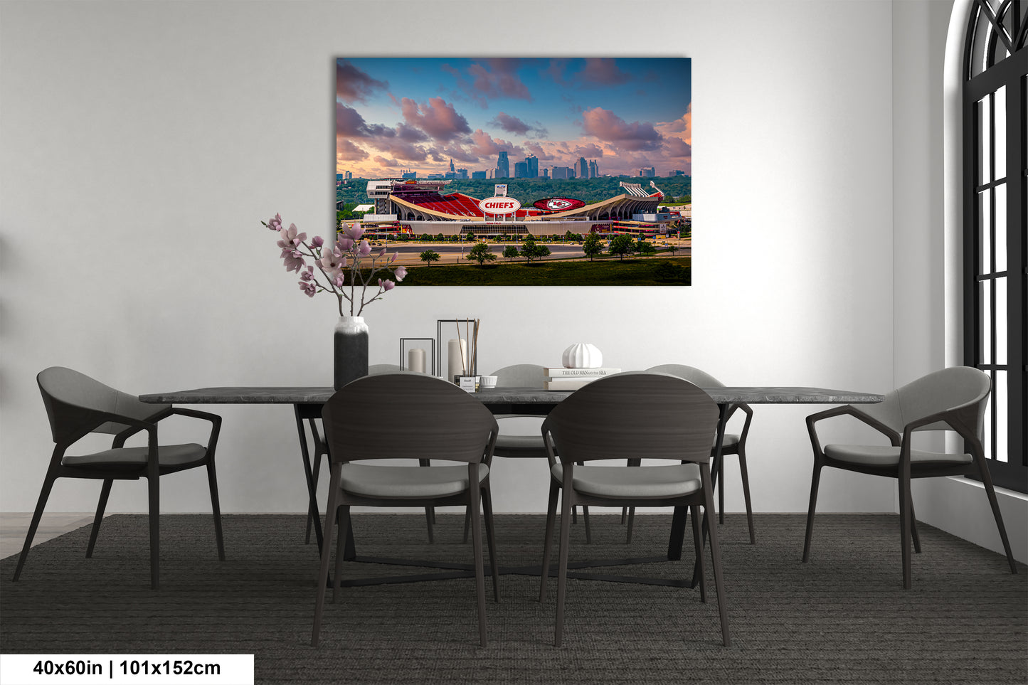 a dining room table with chairs and a painting on the wall