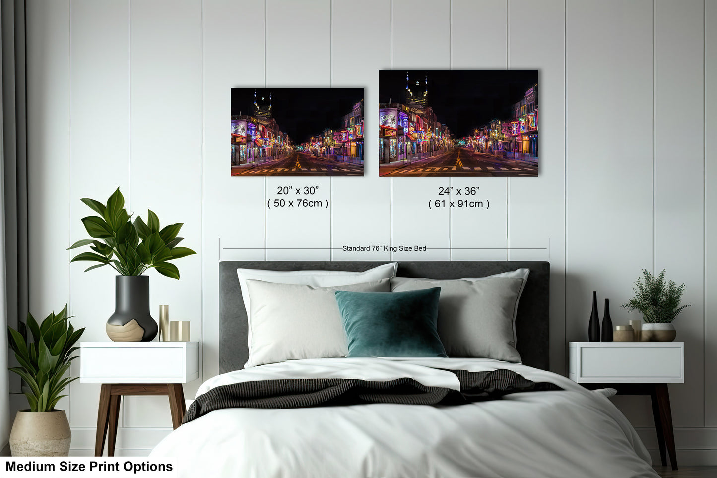 a bed with a white comforter and two pictures on the wall above it