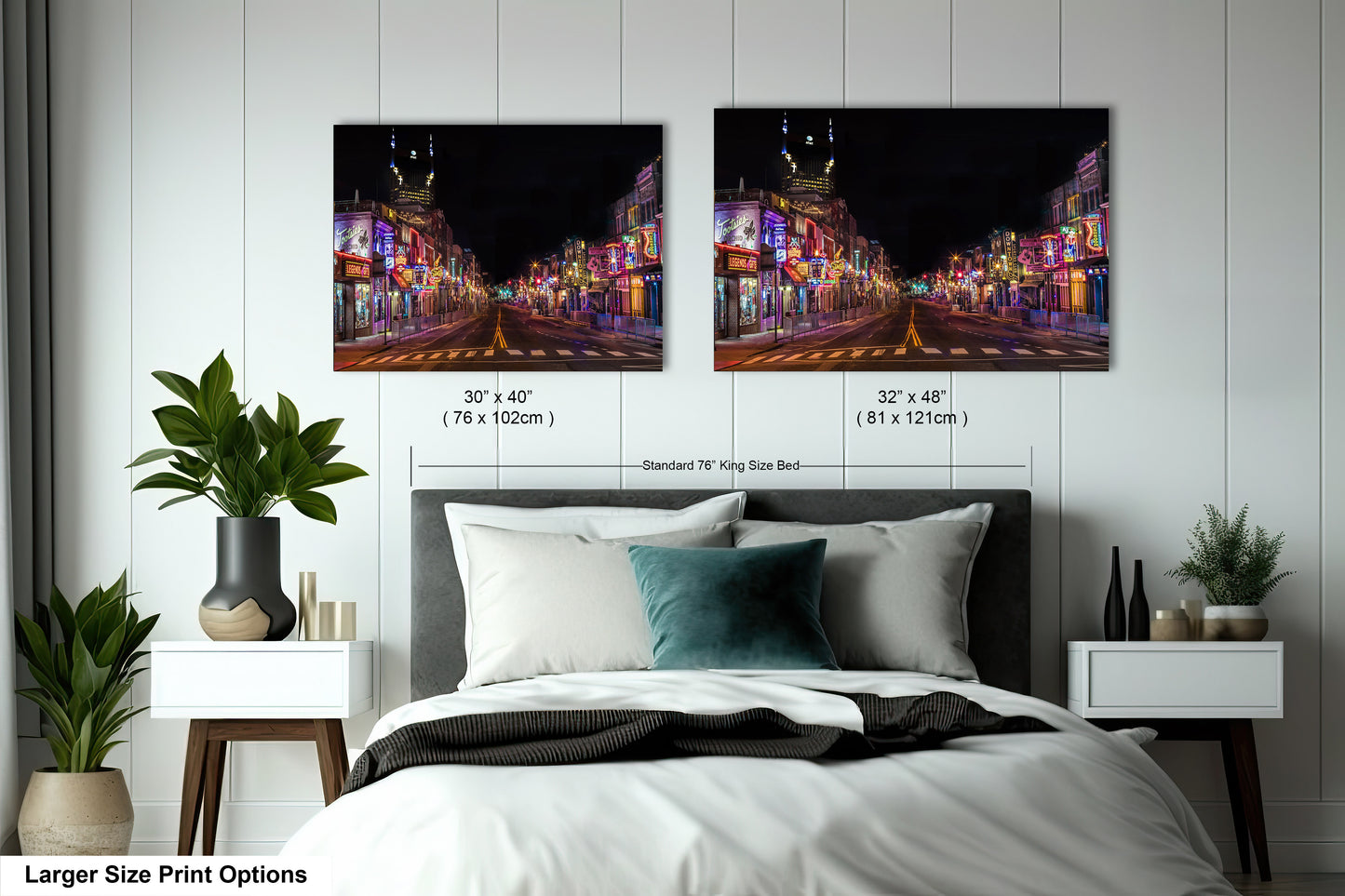 a bed with a white comforter and two pictures on the wall above it