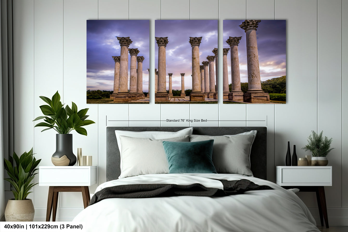 a bed with a white comforter and four paintings on the wall