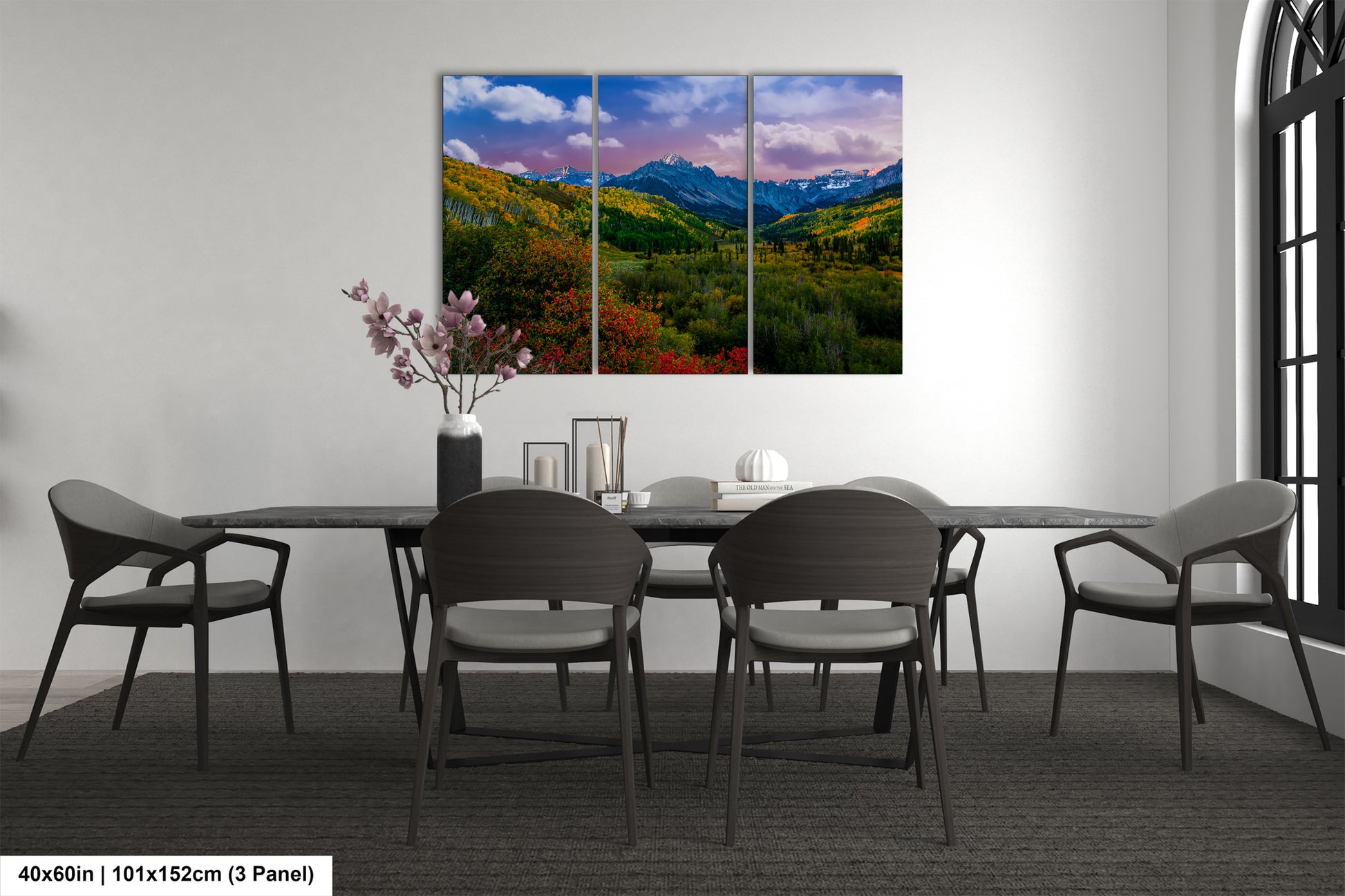 a dining room table with four chairs and a painting on the wall