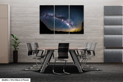 a dining room table with chairs and a wall hanging