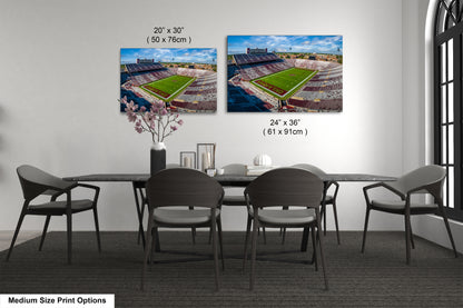 a dining room table with chairs and two pictures of a stadium