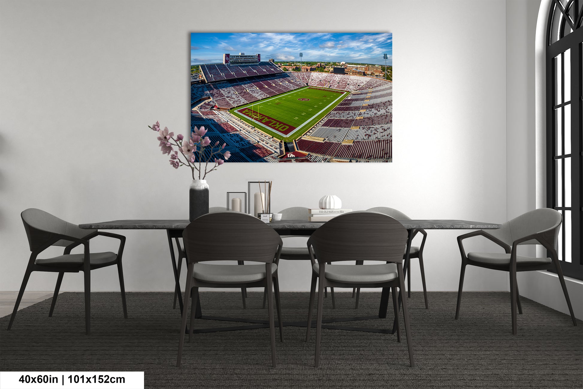 a dining room table with chairs and a painting on the wall