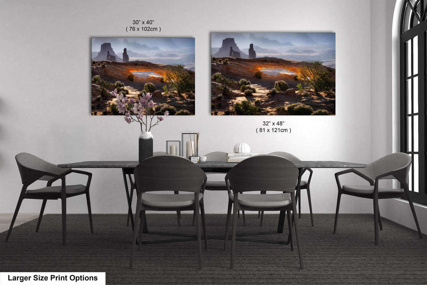 a dining room table with four chairs and two pictures on the wall