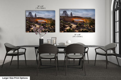 a dining room table with four chairs and two pictures on the wall