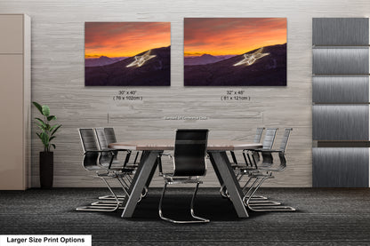 a dining room table with chairs and two pictures on the wall