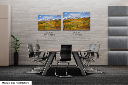 a dining room table with four chairs and two pictures on the wall