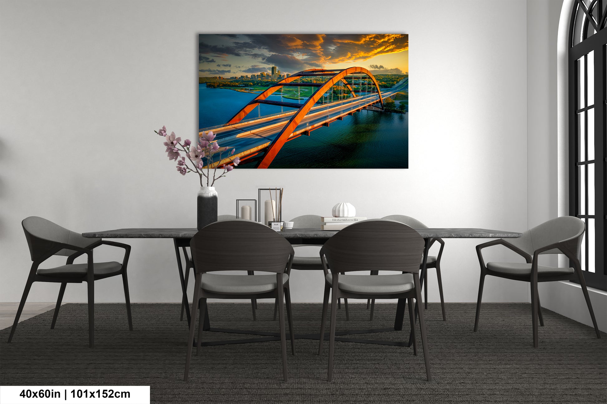 a dining room table with chairs and a painting on the wall