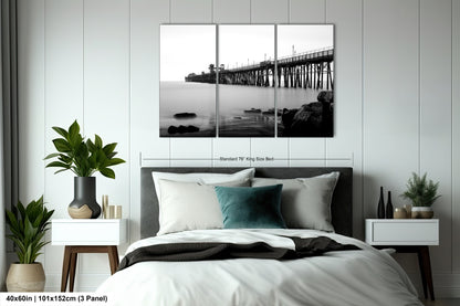 a black and white photo of a bed with a bridge in the background