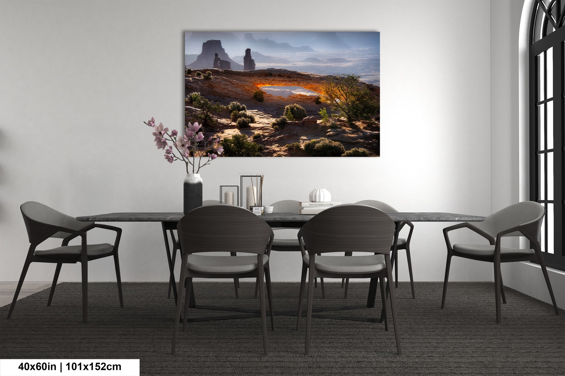 a dining room with a table and chairs and a painting on the wall