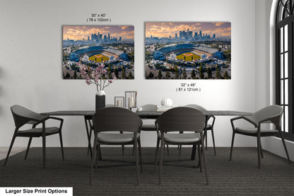 a dining room table with four chairs and two pictures of a stadium