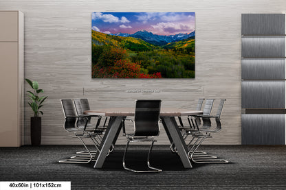 a dining room table with chairs and a painting on the wall