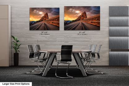 a dining room table with chairs and two pictures on the wall