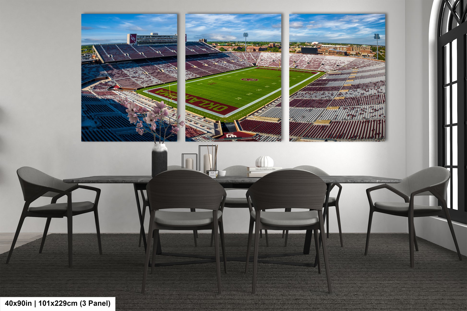 a dining room table with four chairs and a wall mounted picture of a football field