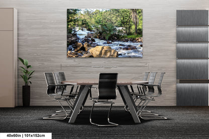 a dining room table with chairs and a painting of a waterfall