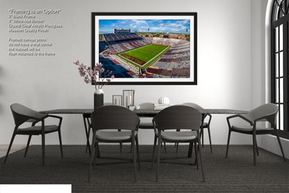 a framed photograph of a football field in a dining room