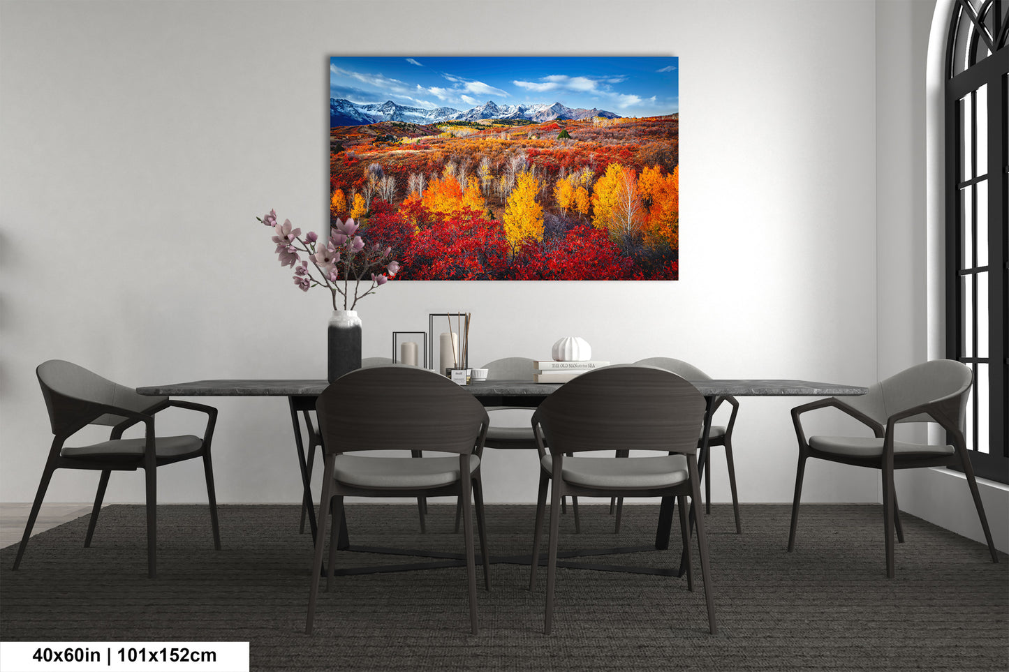 a dining room table with chairs and a painting on the wall