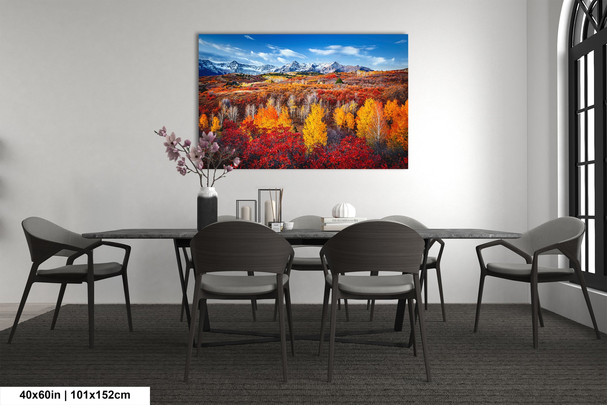 a dining room table with chairs and a painting on the wall