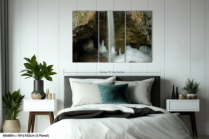 a bed with a white comforter and two paintings on the wall