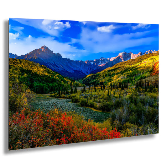 a scenic view of a valley with mountains in the background