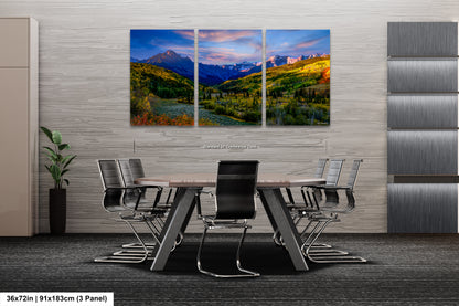 a dining room table with chairs and a painting on the wall