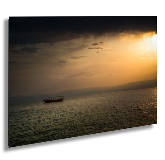 a boat floating on top of a body of water under a cloudy sky