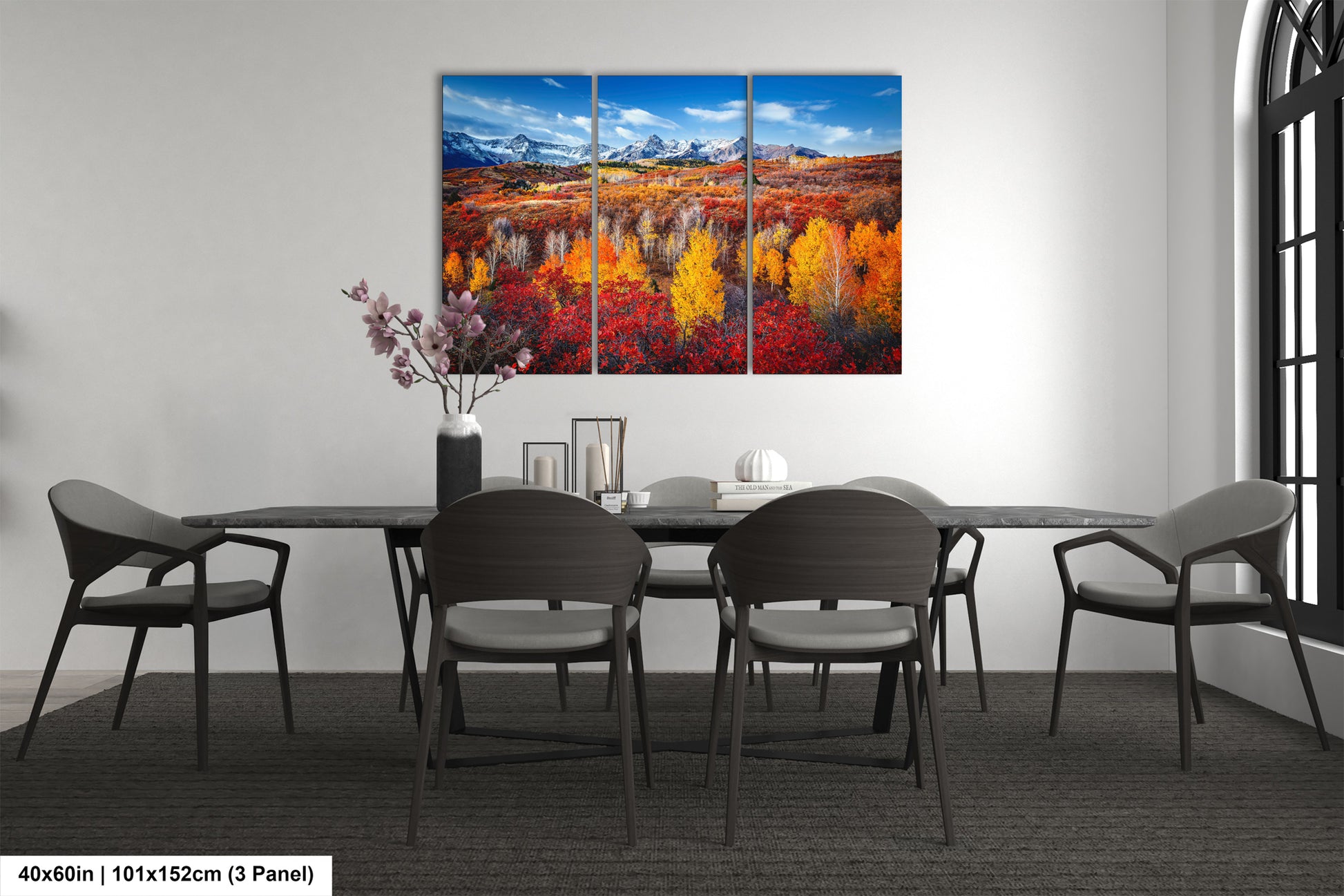 a dining room table with four chairs and a painting on the wall