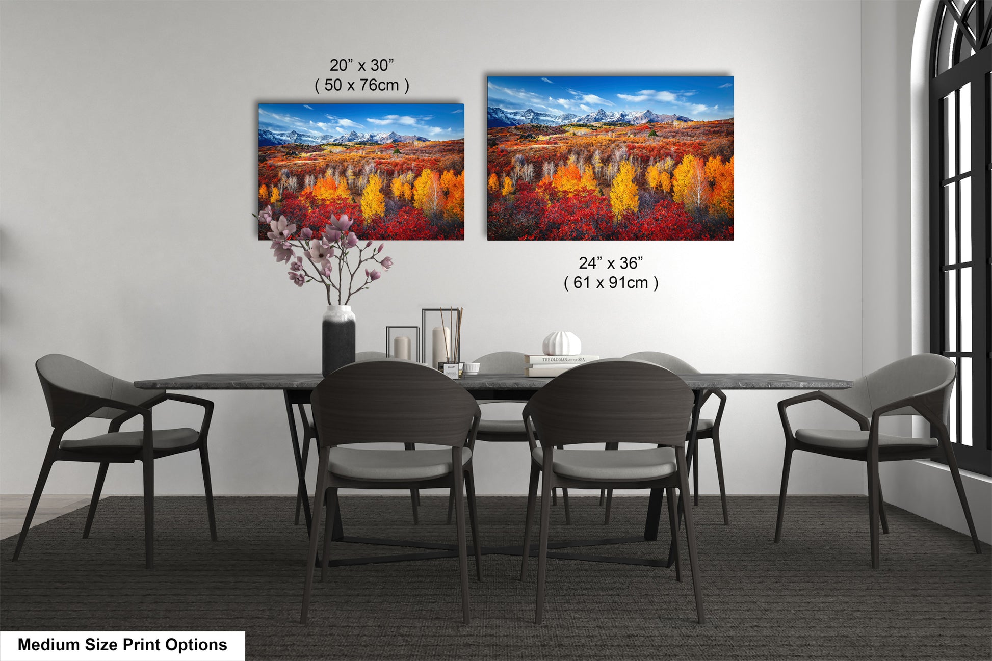 a dining room table with four chairs and two paintings on the wall