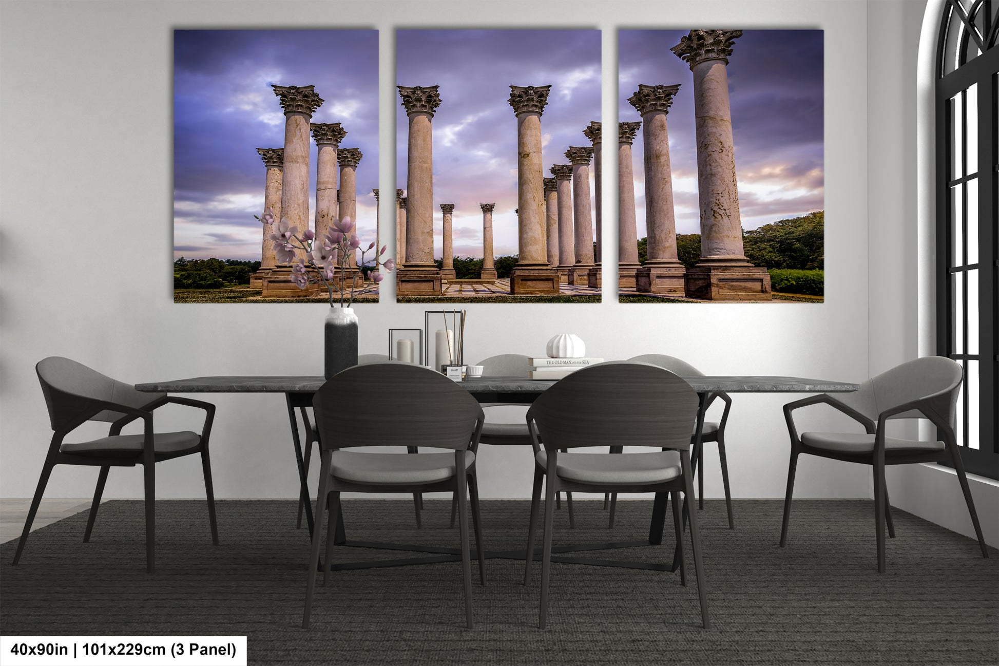 a dining room table with four chairs and four paintings on the wall