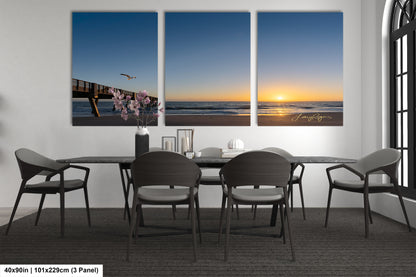 a dining room table with four chairs and a vase of flowers