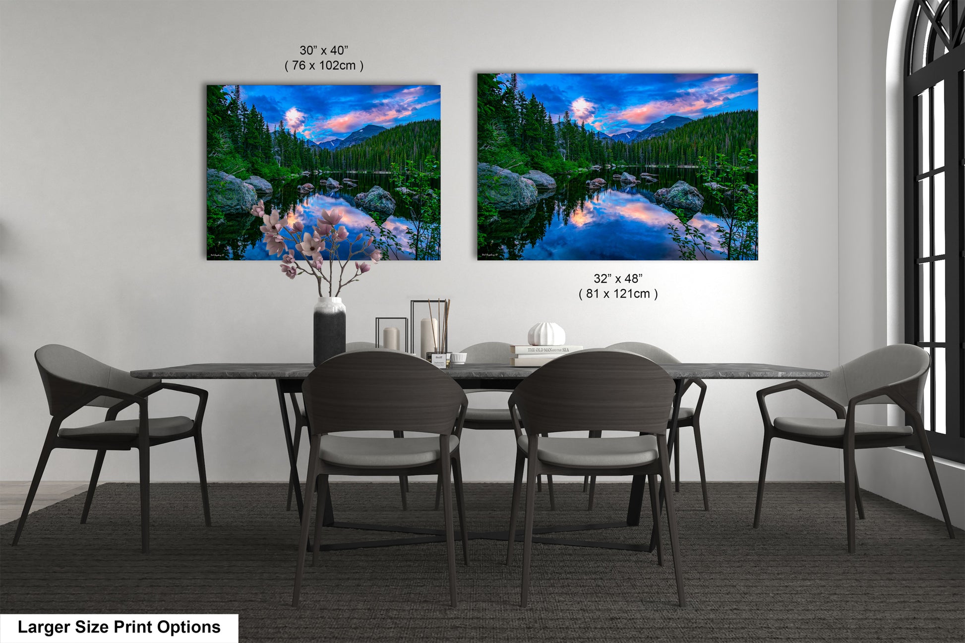 a dining room table with four chairs and two pictures on the wall