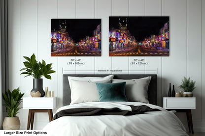 a bed with a white comforter and two pictures on the wall above it