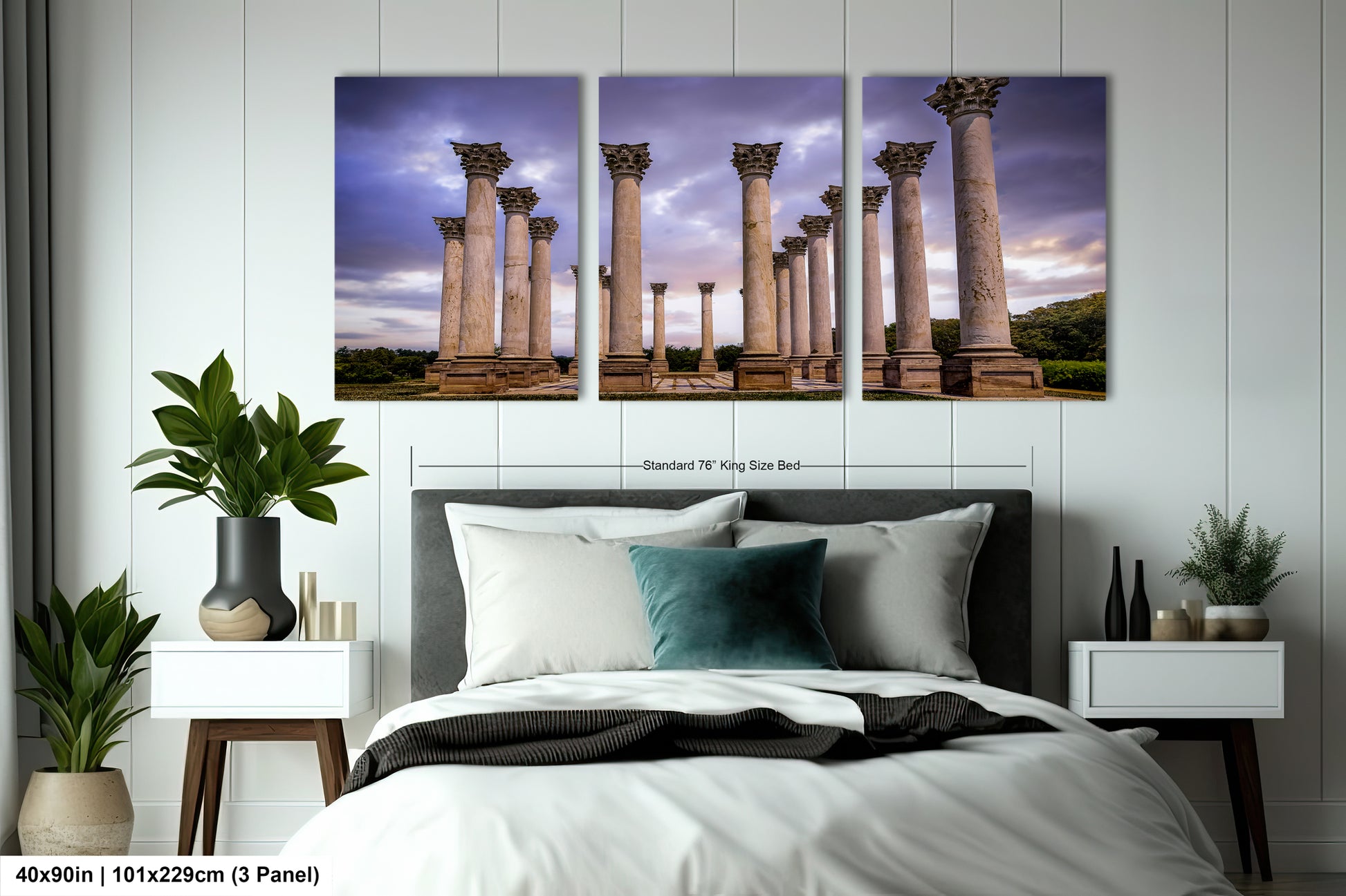 a bed with a white comforter and four paintings on the wall
