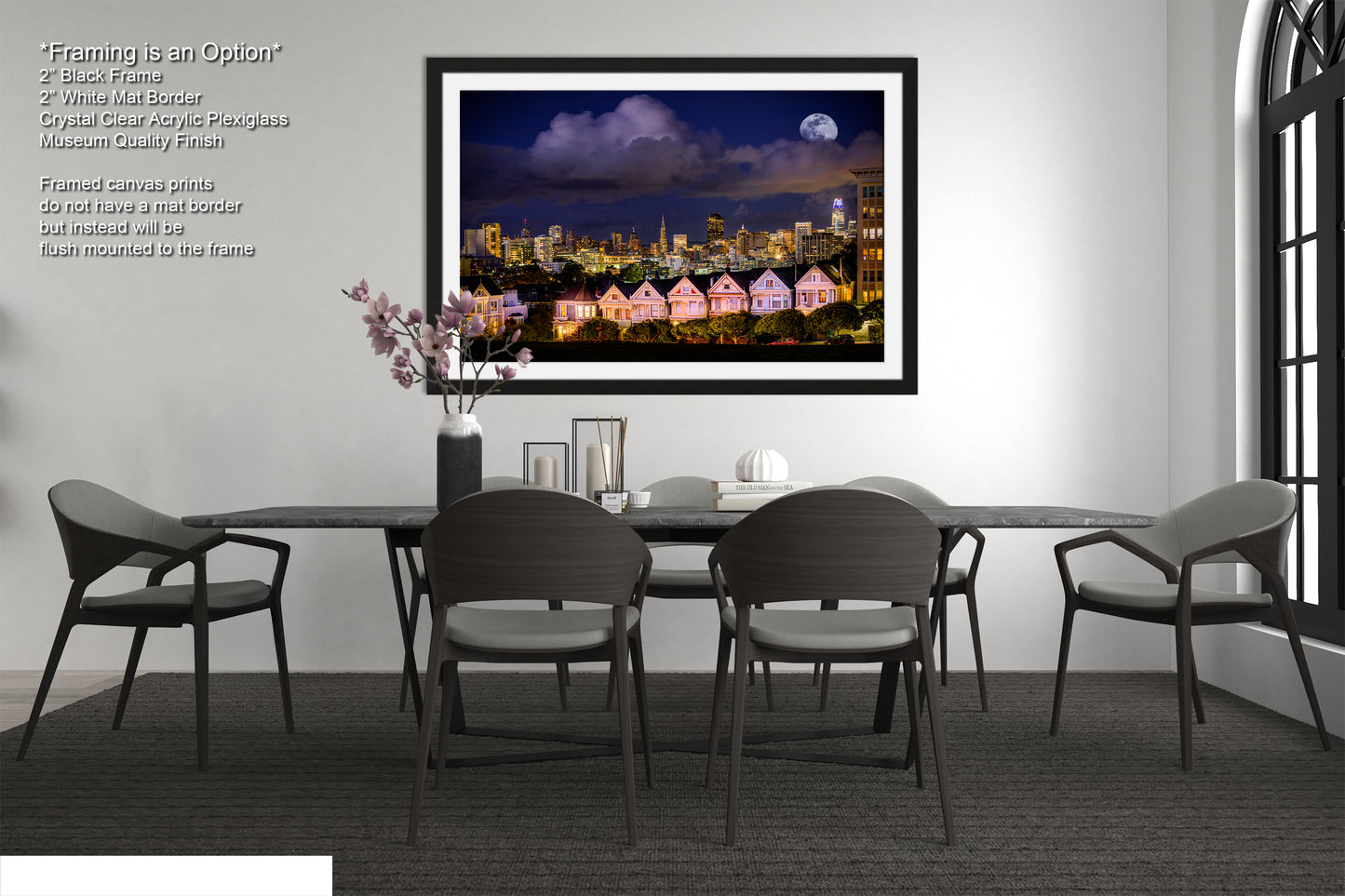 a dining room table with chairs and a picture hanging on the wall